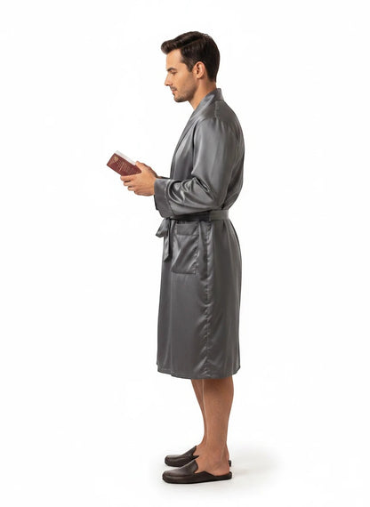 Paradime Enterprise LLC man wearing a grey satin robe while holding a book, side profile view.