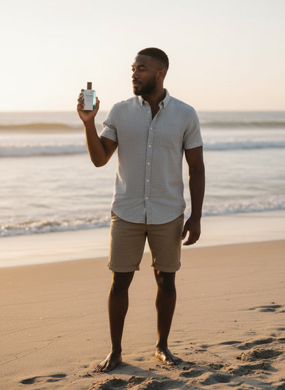 Paradime Enterprise LLC Kanon Nordic Elements Water fragrance held by a man on a beach at sunset