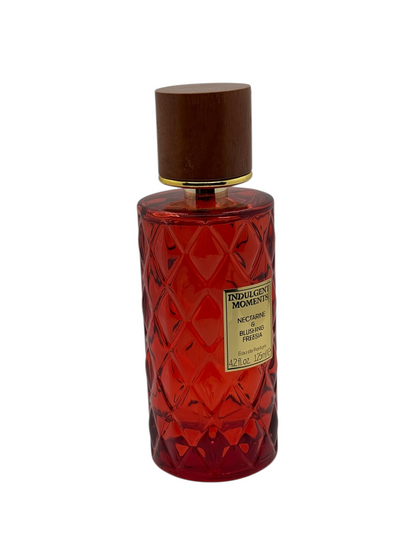 Paradime Enterprise LLC Indulgent Moments Nectarine & Blushing Freesia perfume in a red diamond-pattern glass bottle.