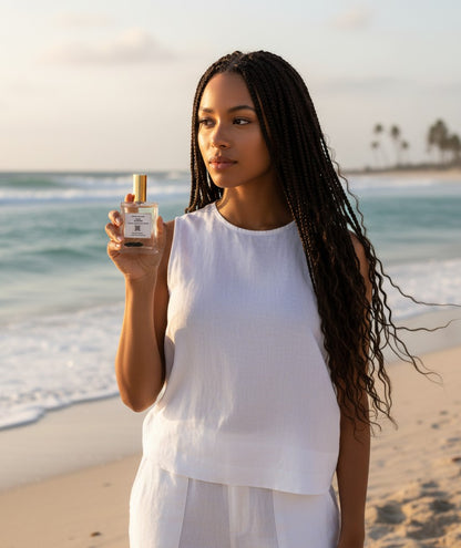 Paradime Enterprise LLC Crystal Beauty Onyx Strength perfume bottle held by a woman on a beach at sunset