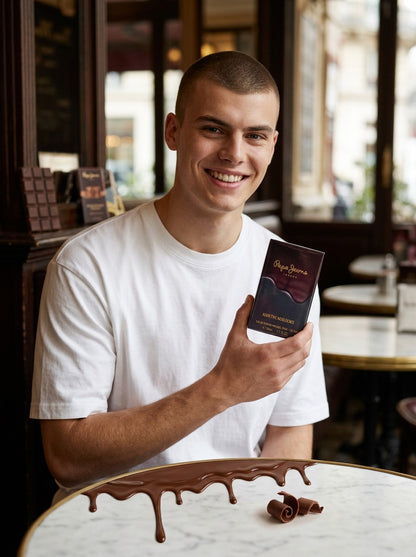 Paradime Enterprise LLC model holding Pepe Jeans Addictive Indulgence fragrance box in a cafe with melted chocolate